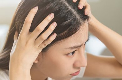 primo piano di una donna che esamina il suo cuoio capelluto